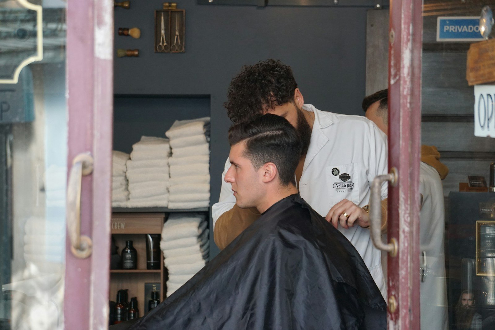 man in white shirt sitting on barber chair